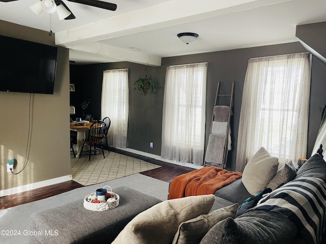 living room with ceiling fan, beamed ceiling, and hardwood / wood-style flooring