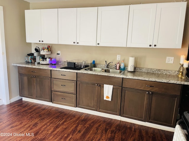 kitchen featuring dark brown cabinetry, dark hardwood / wood-style floors, sink, and white cabinetry