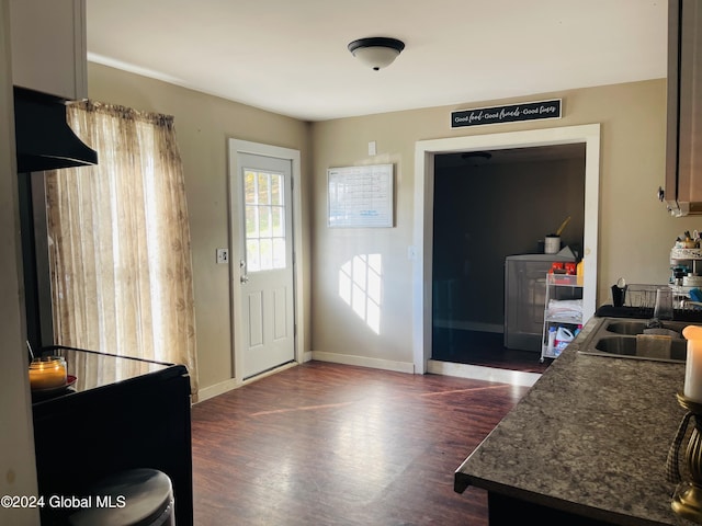 kitchen with washer / dryer, dark wood-type flooring, and sink