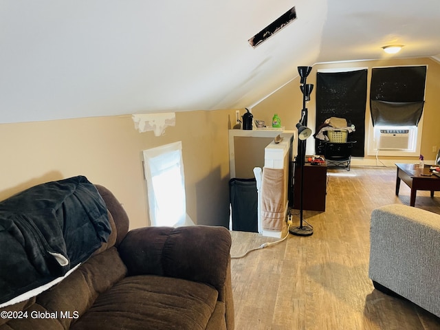 living room featuring cooling unit, lofted ceiling, and light hardwood / wood-style floors