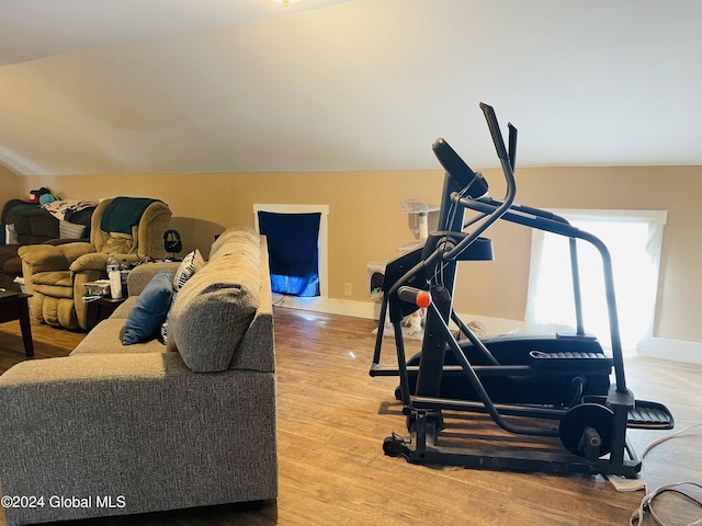 exercise room featuring vaulted ceiling and hardwood / wood-style floors