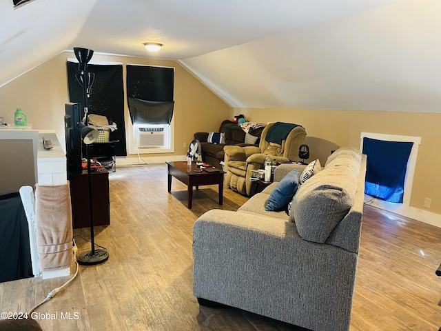 living room featuring cooling unit, vaulted ceiling, and light hardwood / wood-style flooring