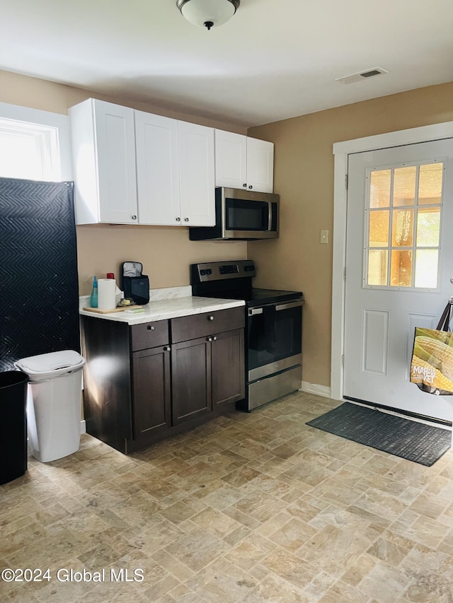 kitchen with dark brown cabinetry, appliances with stainless steel finishes, and white cabinetry