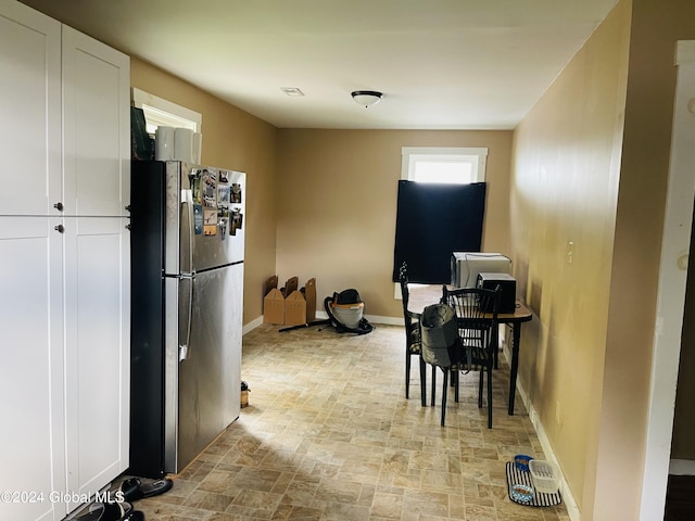 kitchen featuring white cabinets and stainless steel fridge