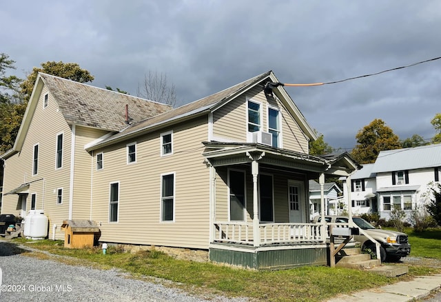 view of side of property featuring covered porch