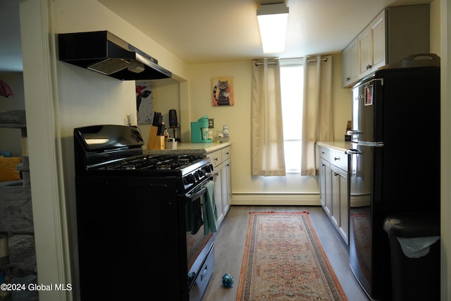 kitchen featuring white cabinets, dark wood-type flooring, extractor fan, black appliances, and a baseboard radiator