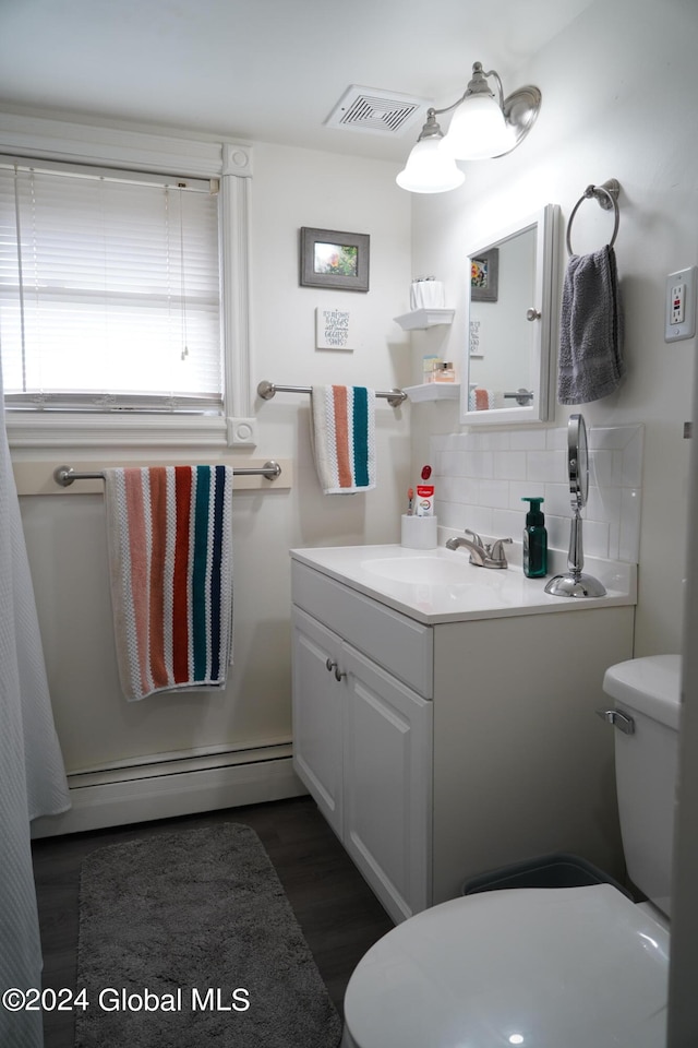 bathroom featuring a baseboard heating unit, tasteful backsplash, hardwood / wood-style floors, vanity, and toilet