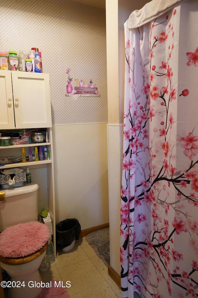 bathroom with walk in shower, tile patterned flooring, and toilet