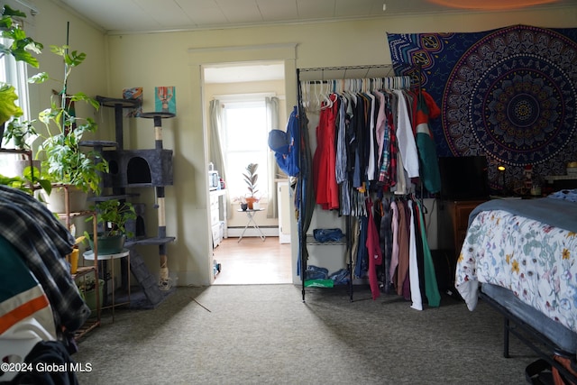 bedroom with carpet floors, baseboard heating, and crown molding