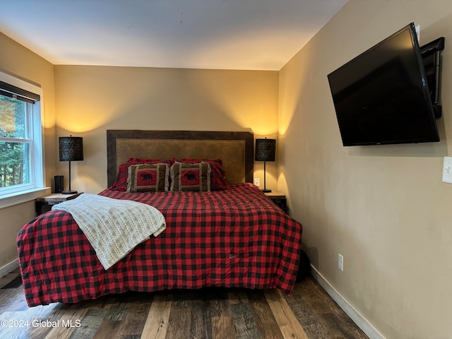 bedroom with wood finished floors and baseboards