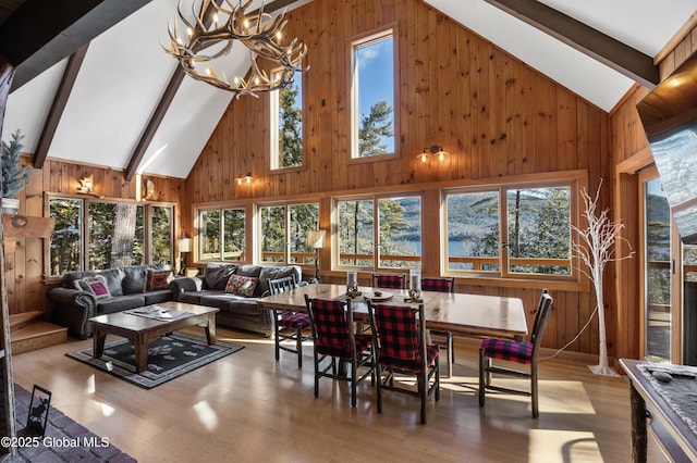 sunroom / solarium featuring an inviting chandelier and vaulted ceiling with beams