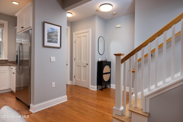 entryway with light wood finished floors, baseboards, recessed lighting, and stairway