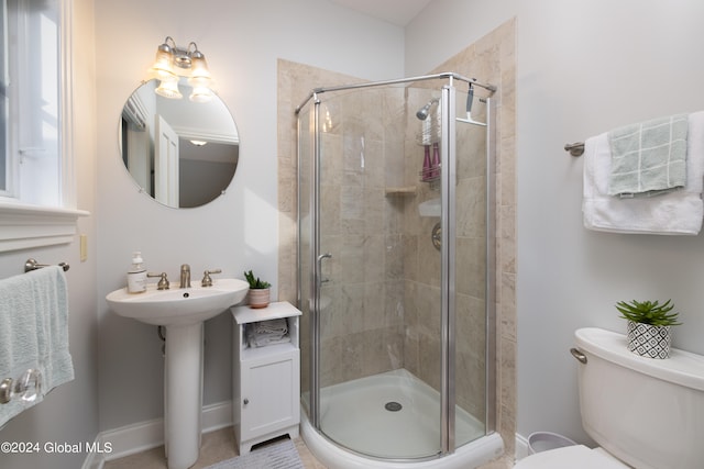 bathroom with toilet, sink, and an enclosed shower