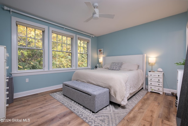 bedroom featuring baseboards, wood finished floors, and ceiling fan
