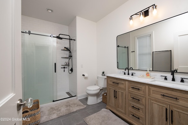 bathroom with tile patterned flooring, vanity, toilet, and a shower with shower door