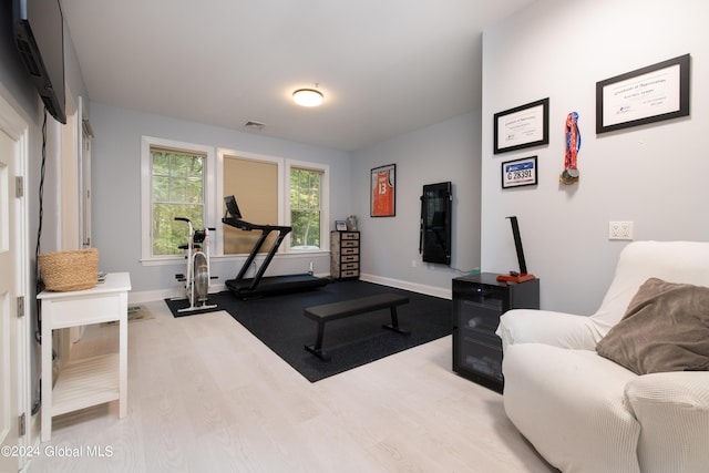 workout room featuring baseboards, visible vents, and wood finished floors
