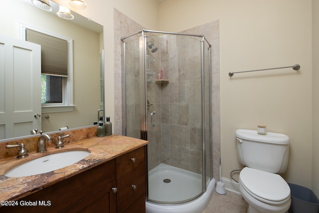 bathroom featuring vanity, a shower with shower door, and toilet