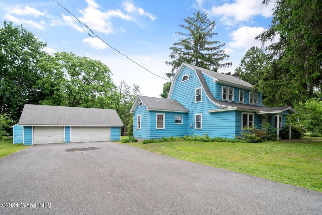 view of front of house featuring a front yard, an outbuilding, and a garage