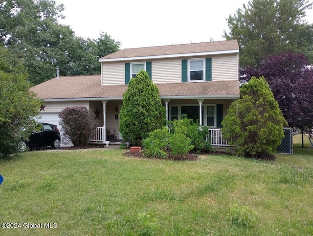 traditional home with covered porch, an attached garage, and a front yard