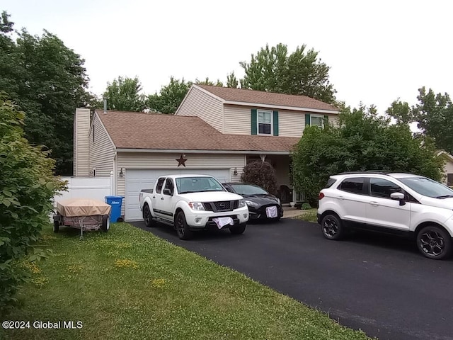 view of property with a front yard and a garage