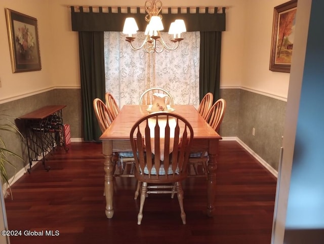 dining area with dark wood-type flooring and a chandelier