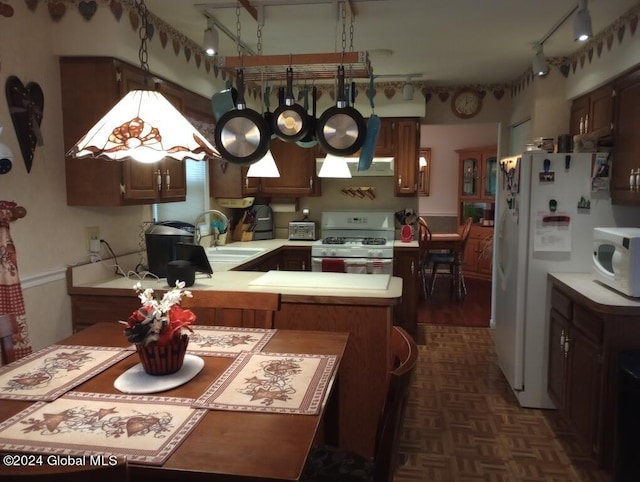 kitchen featuring dark parquet floors, kitchen peninsula, sink, and white appliances