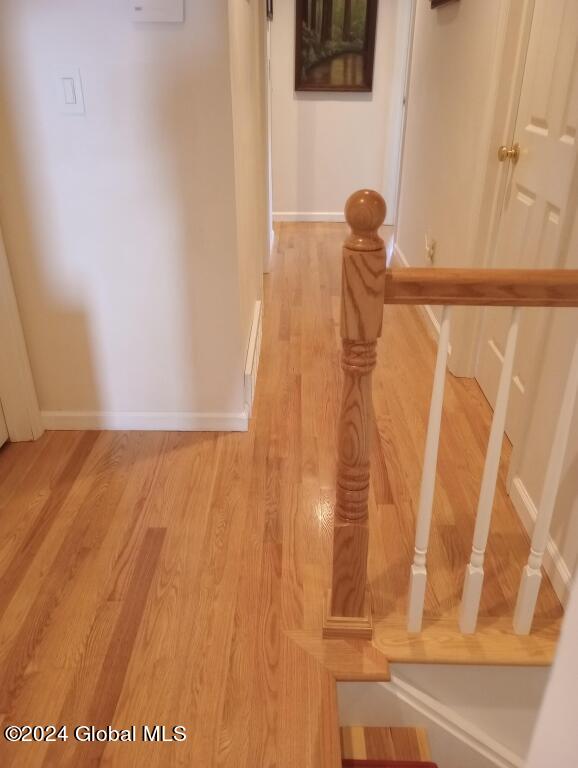 hallway with light hardwood / wood-style floors