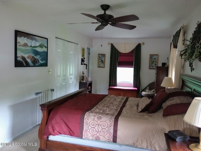 carpeted bedroom featuring ceiling fan and a closet