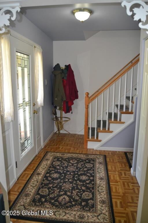 foyer featuring stairs and baseboards