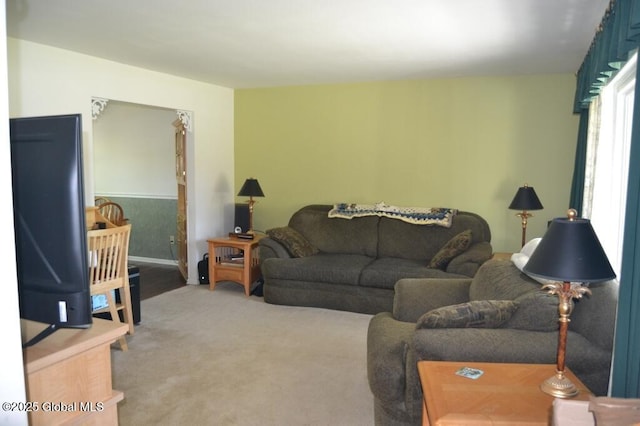living area with light carpet and baseboards