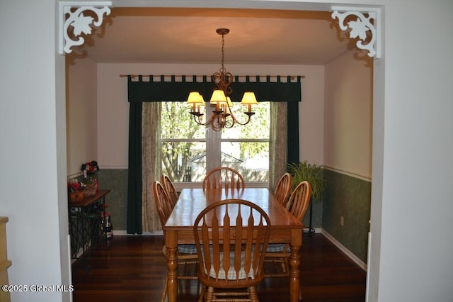 dining area with a chandelier, wood finished floors, and baseboards