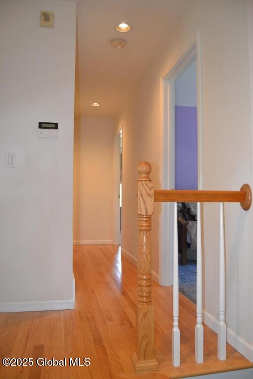 hall with wood finished floors, baseboards, and recessed lighting