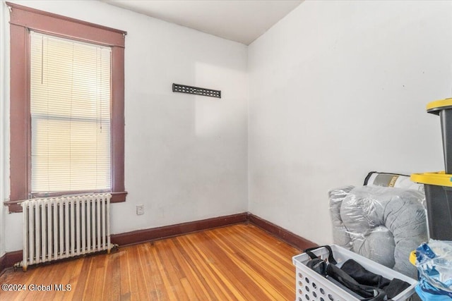 spare room featuring radiator heating unit and wood-type flooring