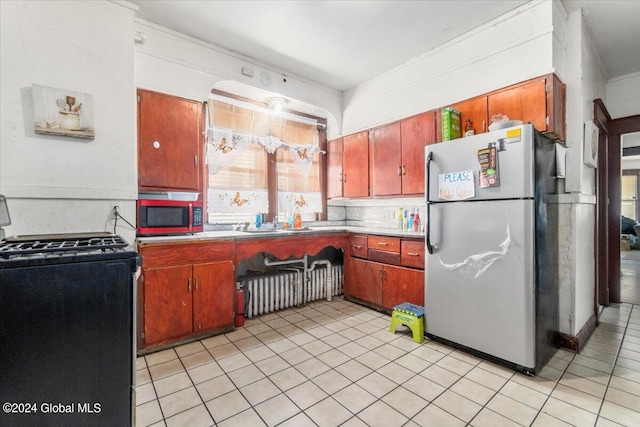 kitchen featuring backsplash, stainless steel appliances, crown molding, and light tile patterned floors