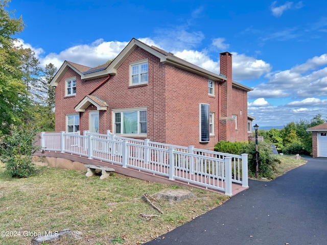 view of front of house with a deck and a front lawn