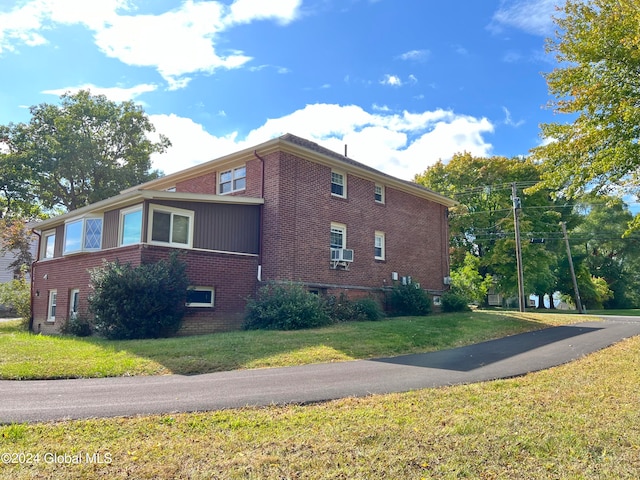 view of property exterior with cooling unit and a yard