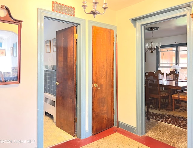 hallway with radiator heating unit and a chandelier