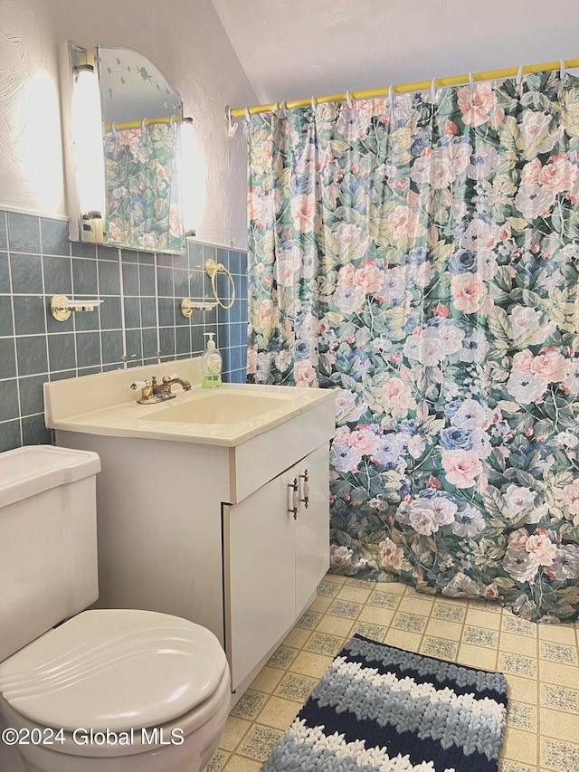 bathroom with tile walls, toilet, and vanity