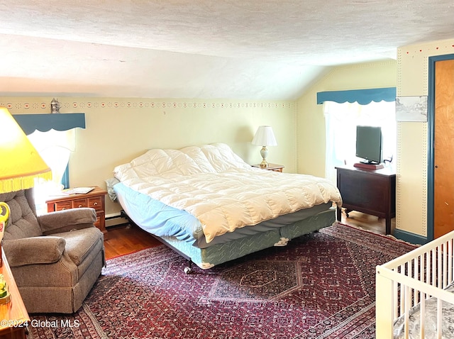 bedroom featuring hardwood / wood-style floors, a textured ceiling, vaulted ceiling, and a baseboard heating unit