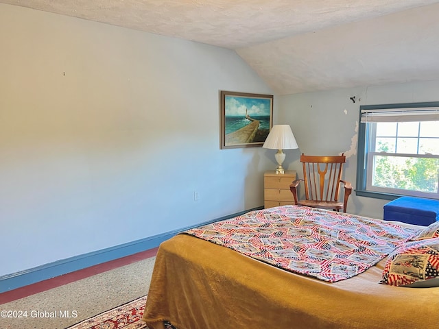 bedroom with a textured ceiling and vaulted ceiling