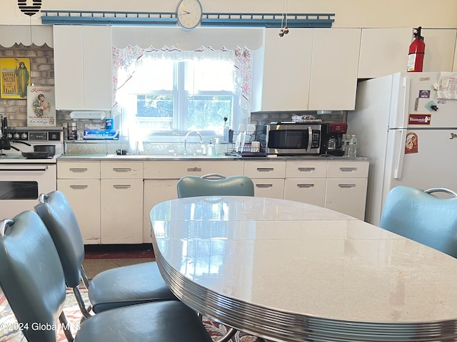 kitchen featuring white cabinets, backsplash, and white fridge