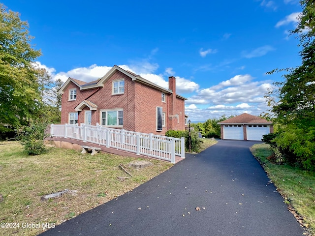 view of front of home featuring an outdoor structure, a garage, and a front lawn