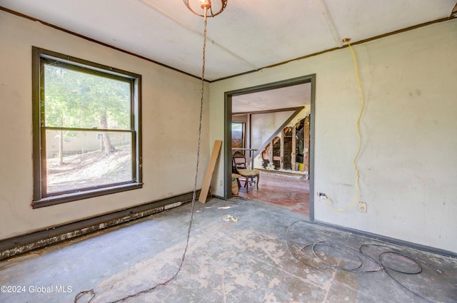 unfurnished room with ornamental molding and stairs