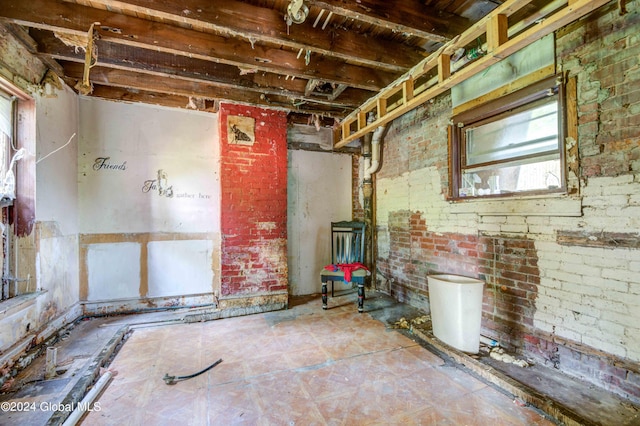 basement featuring brick wall and a wood stove