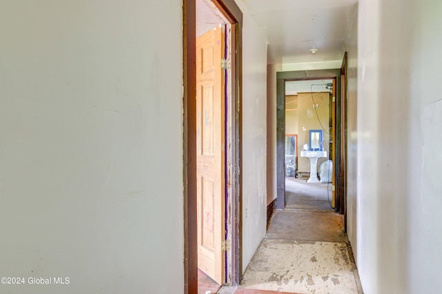 hallway with unfinished concrete flooring