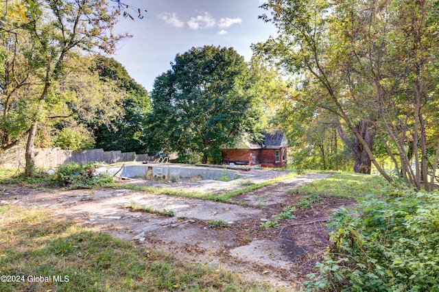 view of yard with a swimming pool and fence