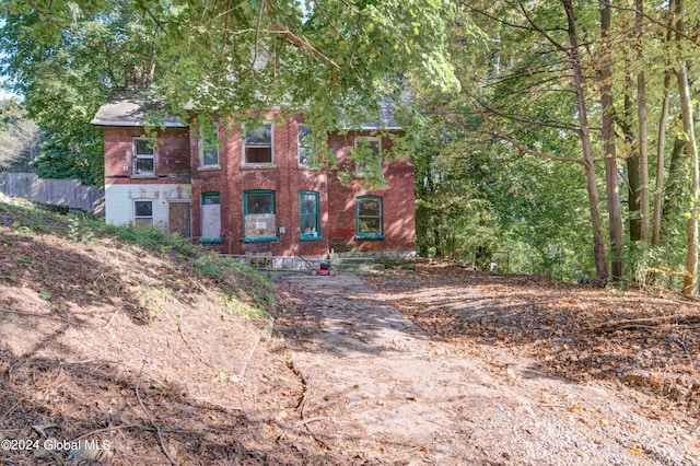 view of front of house featuring brick siding and fence