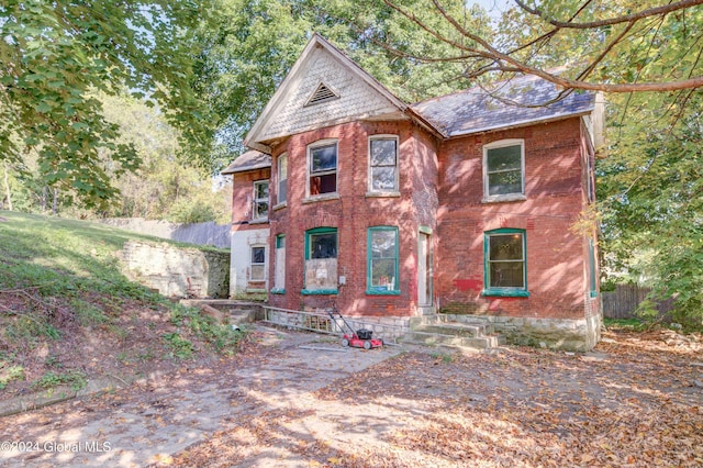 victorian-style house with brick siding and fence