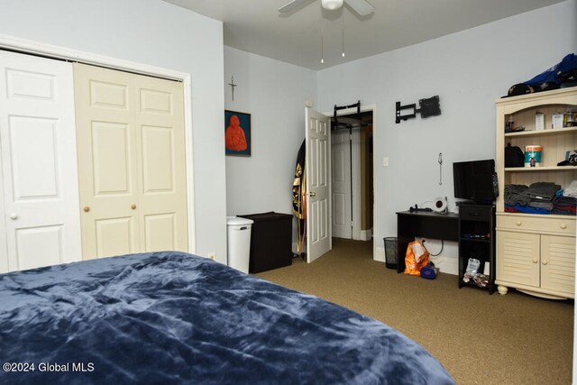 carpeted bedroom featuring ceiling fan and a closet