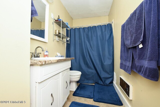 full bath featuring toilet, vanity, and tile patterned floors